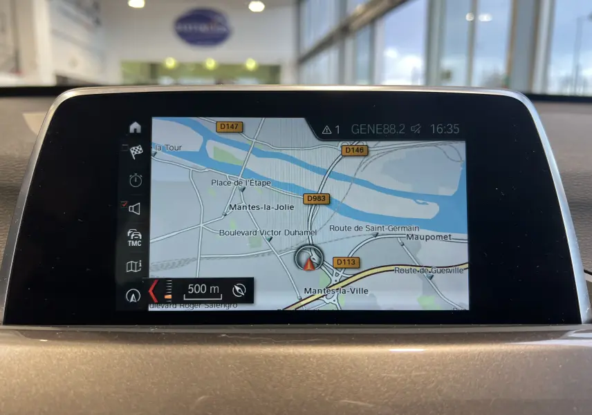 Écran de navigation GPS intégré dans le tableau de bord d'une BMW X1 F48 noire, vue intérieure frontale.