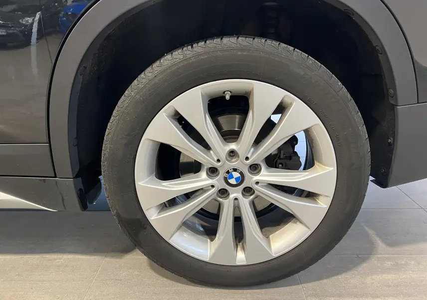 Gros plan sur la roue avant droite du BMW X1 F48 noir Saphirschwarz avec jante alliage à 10 branches.