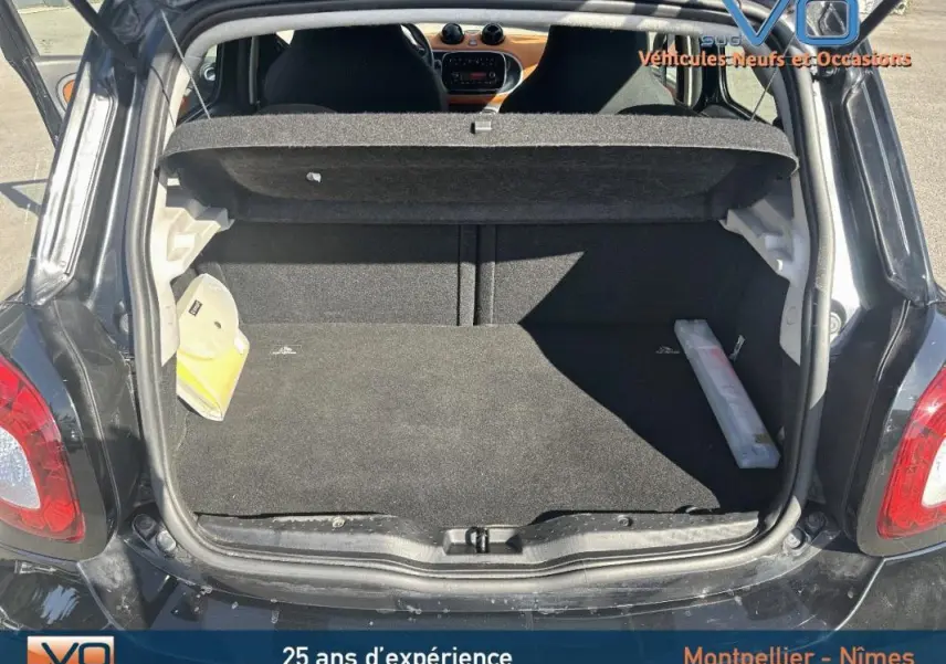 Coffre ouvert d'une Smart Forfour noire de 2015, vue arrière montrant l'espace de chargement et l'intérieur du véhicule.