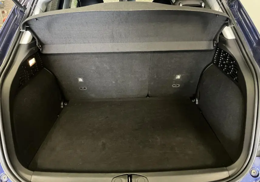 Coffre ouvert vu de l'arrière d'une Fiat 500X bleu, montrant l'espace de chargement et la plage arrière.