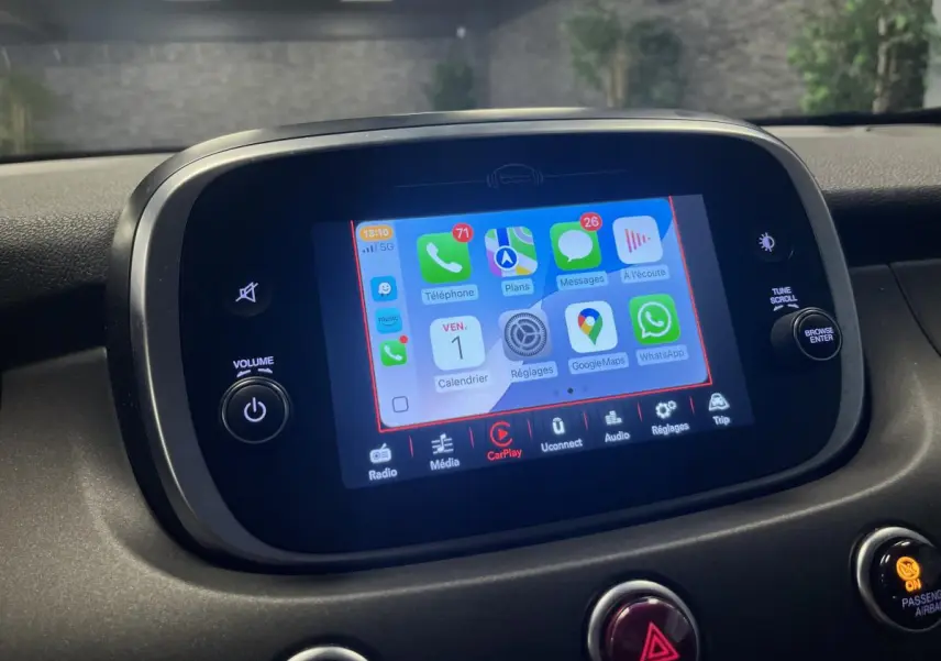 Écran tactile central du tableau de bord de la Fiat 500X 2024 affichant Apple CarPlay dans un intérieur noir.