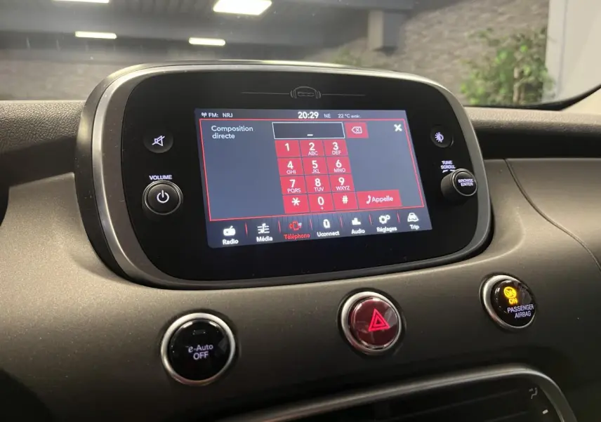 Écran tactile central du tableau de bord de la Fiat 500X 2024, vue intérieure avant avec commandes et indicateurs lumineux.