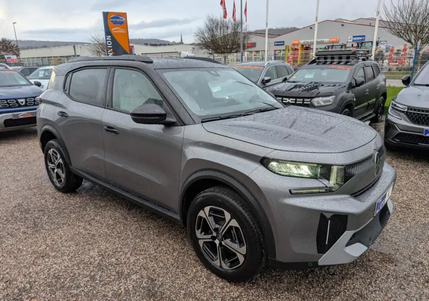 Vue 3/4 avant d'un Citroën C3 Aircross 2025 gris métallisé avec toit noir et jantes alliage 17 pouces.