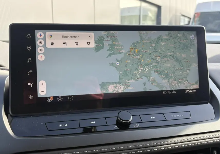 Vue rapprochée de l'écran tactile du tableau de bord du Nissan Qashqai noir, affichant une carte de navigation.