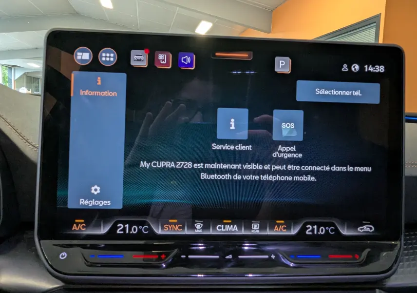 Écran tactile central de 12,9 pouces du CUPRA LEON ST gris, affichant les options de service client et appel d'urgence.