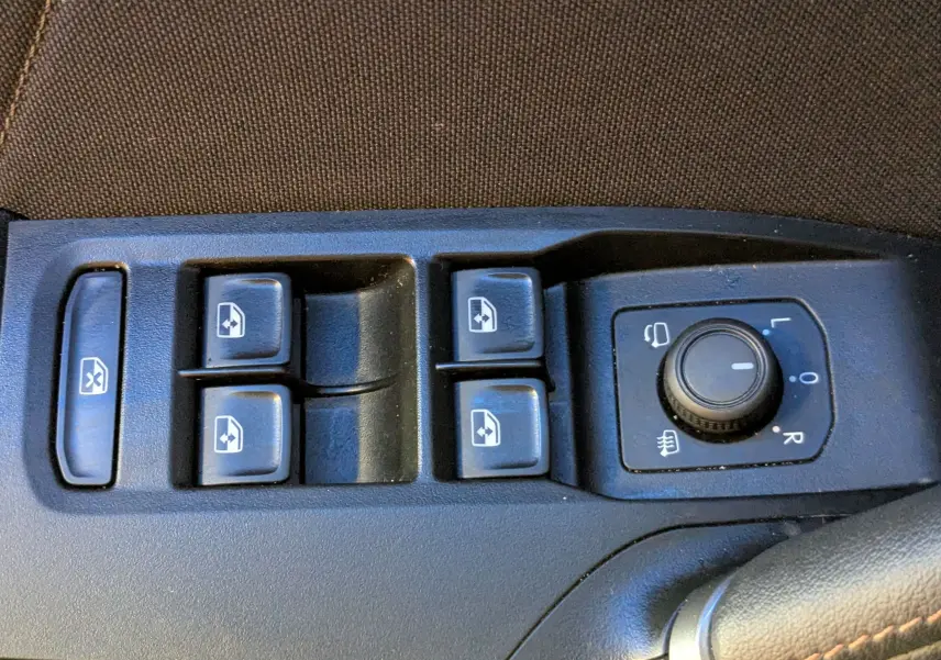 Gros plan sur les commandes de lève-vitres et réglage des rétroviseurs dans une CUPRA Leon ST gris Magnetic.