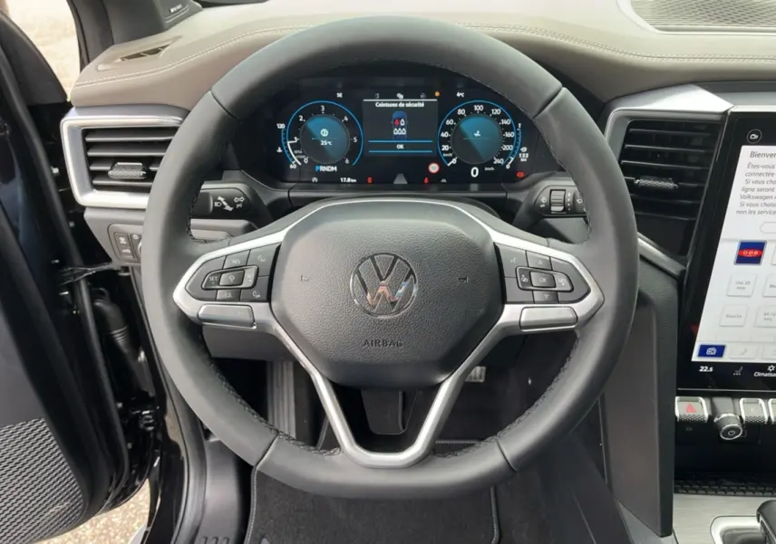 Vue rapprochée du volant cuir multifonctions et tableau de bord digital du Volkswagen Amarok noir 2025, version V6 Aventura.