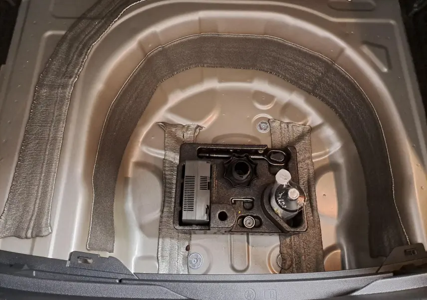 Vue rapprochée du coffre du Volkswagen Taigo 2025, montrant le rangement sous plancher en métal argenté.