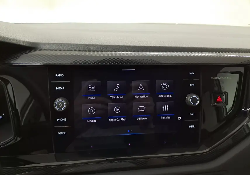 Écran tactile central du Volkswagen Taigo 2025 avec interface multimédia et commandes autour en finition noire brillante.