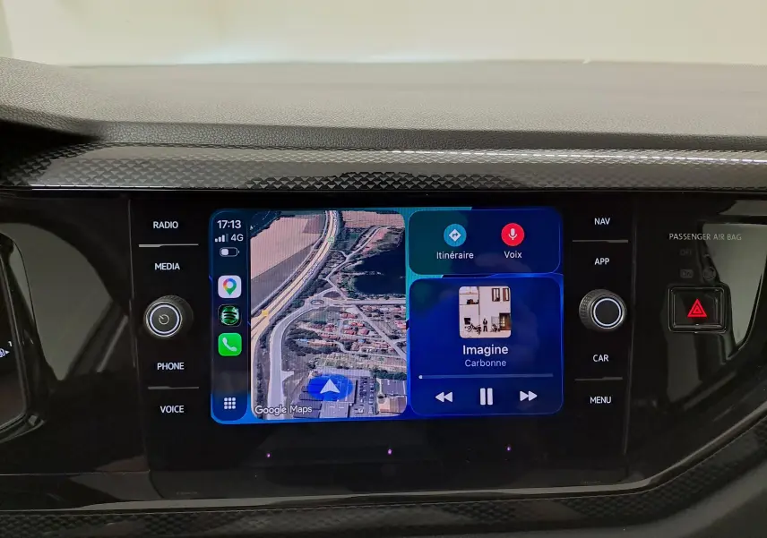 Écran tactile central du Volkswagen Taigo 2025 affichant la navigation Google Maps et la lecture musicale, entouré de commandes noires.