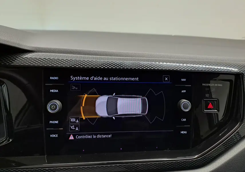 Écran tactile intérieur montrant le système d'aide au stationnement du Volkswagen Taigo 2025 en vue de dessus du véhicule.
