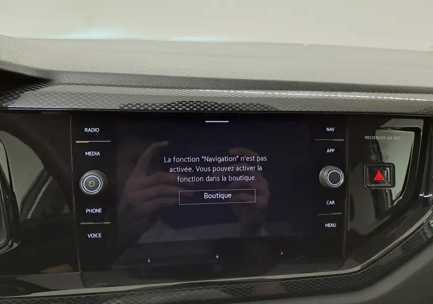 Écran tactile central du Volkswagen Taigo 2025 avec message d'activation de la navigation, entouré de boutons noirs brillants.