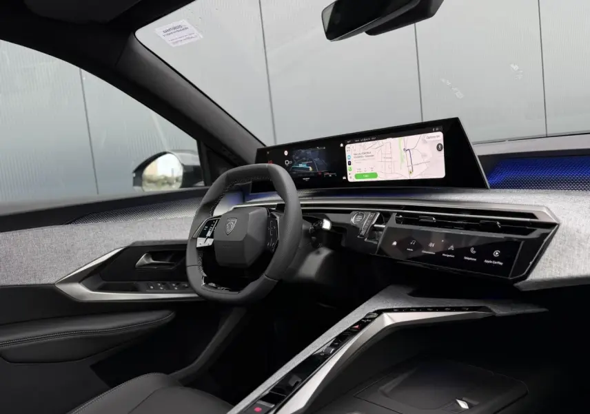 Intérieur Peugeot 3008 Hybrid 145 GT vu côté conducteur, tableau de bord numérique panoramique et volant compact noir.