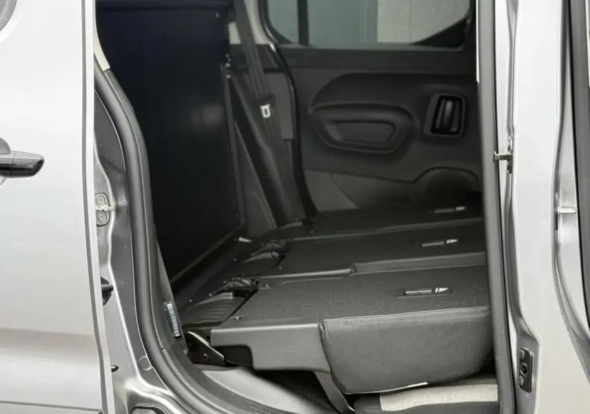 Vue intérieure côté droit du Citroën Berlingo Multispace gris acier avec sièges arrière escamotés et porte coulissante ouverte.
