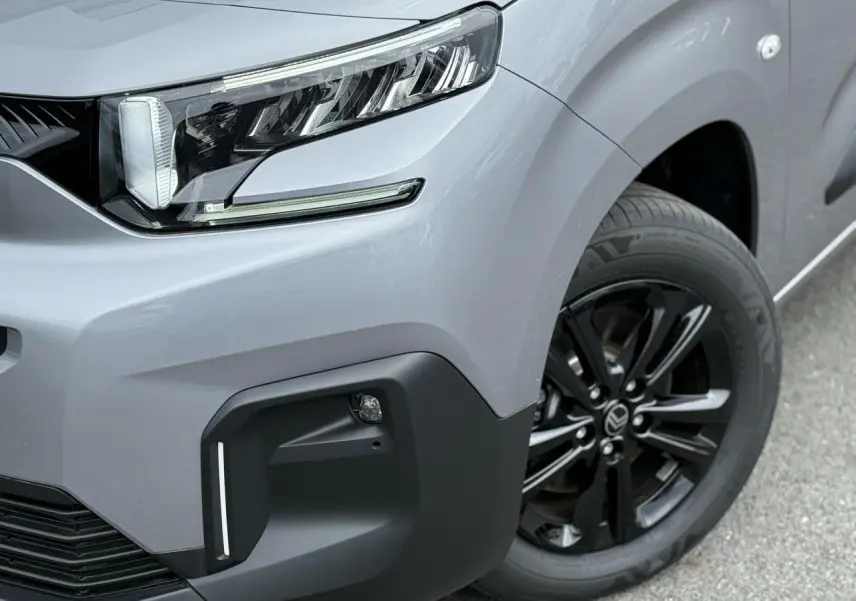 Gros plan sur l'avant droit du Citroën Berlingo Multispace gris acier, avec projecteur LED et jante alliage noire.
