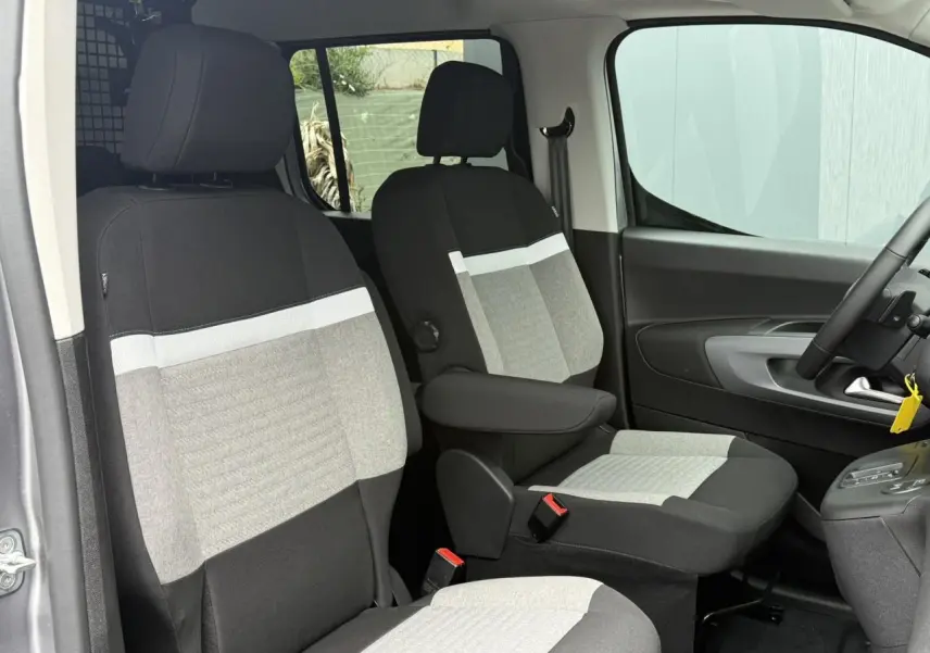 Vue intérieure côté droit du Citroën Berlingo Multispace 2026, sièges avant bicolores gris et noir avec accoudoir.