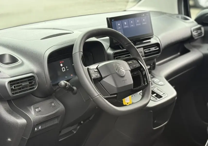 Vue intérieure du poste de conduite du Citroën Berlingo Multispace 2026, volant multifonctions et écran tactile central.