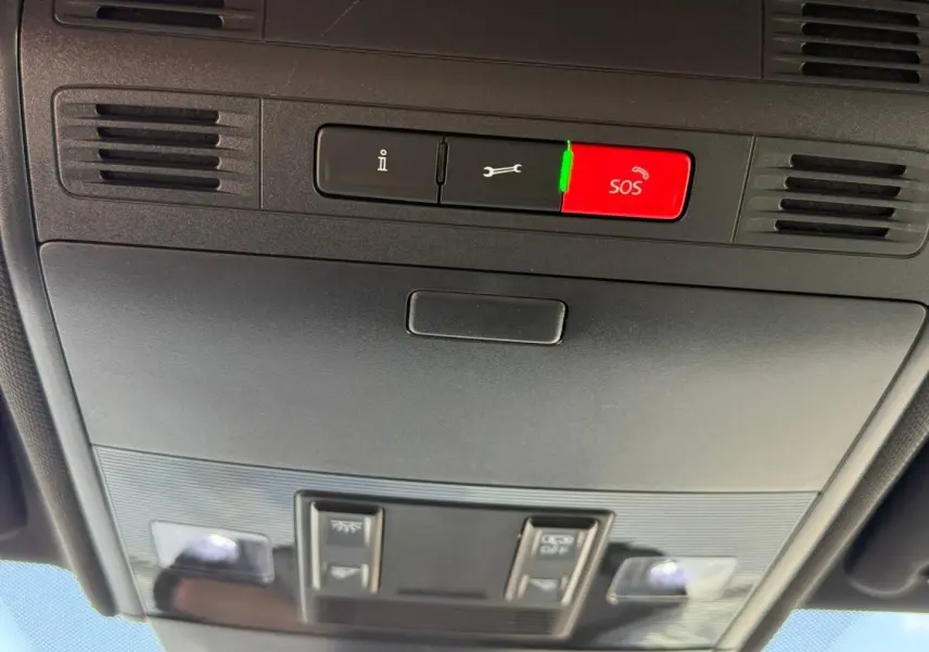 Vue en contre-plongée du plafonnier gris avec bouton SOS rouge et commandes d’éclairage dans un Volkswagen Taigo 2025.
