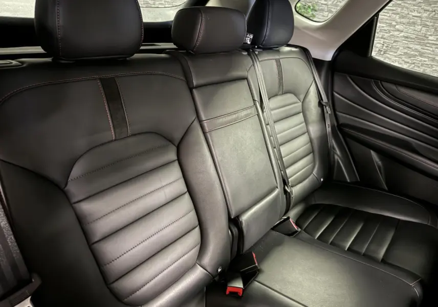 Vue intérieure du siège arrière cuir noir avec surpiqûres rouges du MG MOTOR EHS 1.5T Luxury 2022.