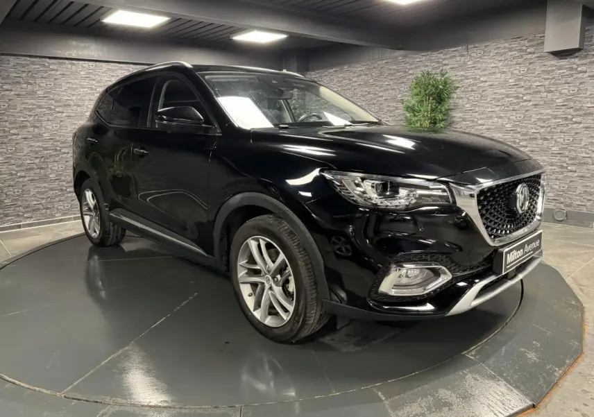 MG MOTOR EHS noir métallisé en 3/4 avant droit, avec calandre chromée et jantes alliage visibles.