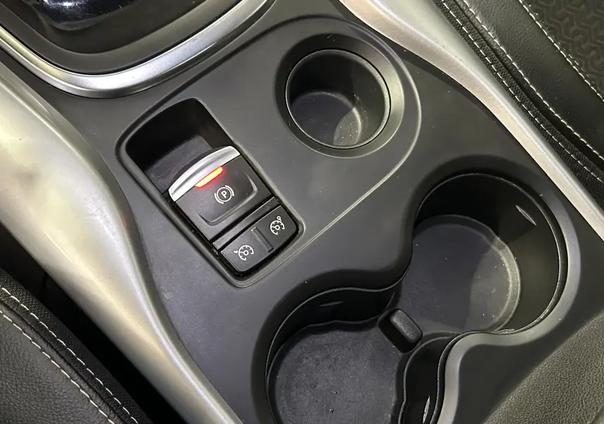 Gros plan sur la console centrale du Renault Kadjar TCe 130 avec frein à main électronique et porte-gobelets noirs.