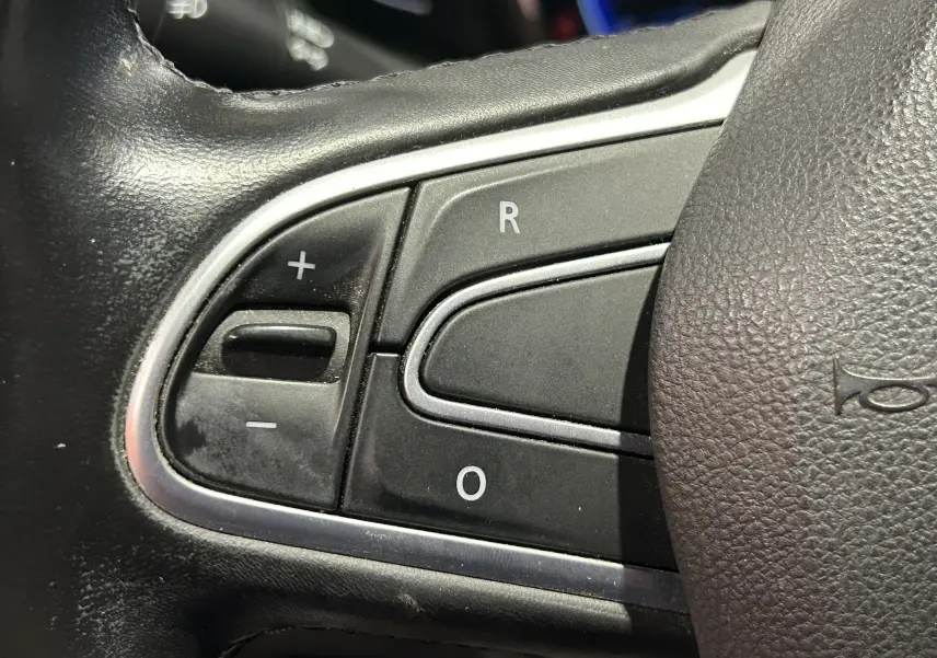 Gros plan sur les commandes du volant noir du Renault Kadjar TCe 130 EDC energy Intens 2017, boutons +, -, R et O visibles.