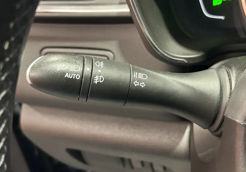 Gros plan sur la commande des feux et clignotants du Renault Kadjar TCe 130, intérieur noir et gris.