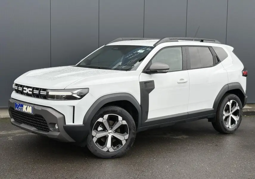 SUV Dacia Duster blanc glacier vu en 3/4 avant droit, avec jantes alliage et barres de toit noires.