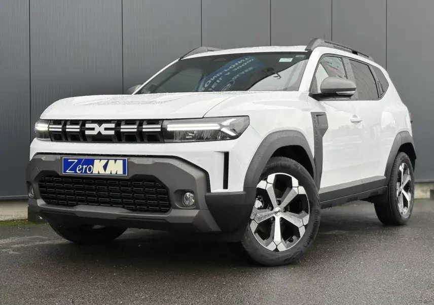 SUV Dacia Duster blanc glacier vu en 3/4 avant droit, avec calandre noire et jantes alliage bicolores.