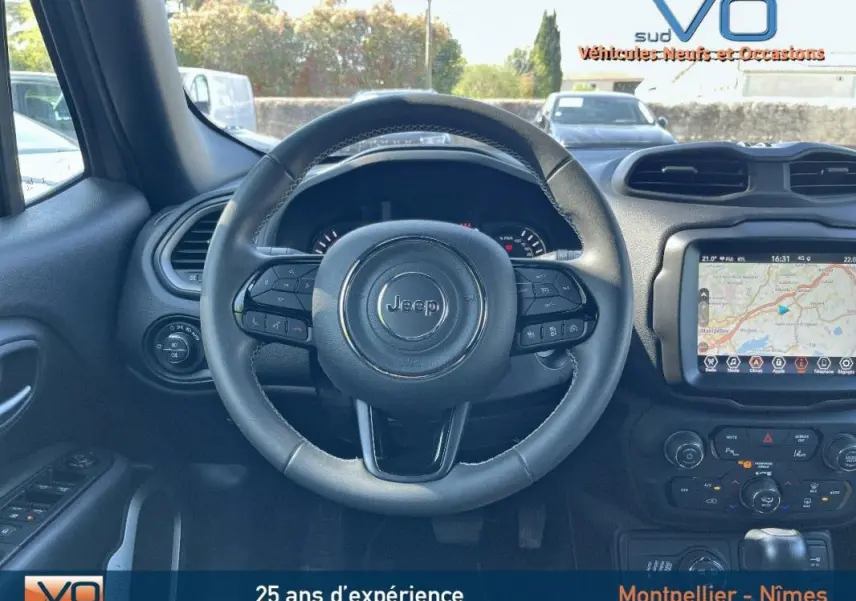 Vue intérieure centrée sur le volant Jeep noir avec tableau de bord et écran tactile affichant un GPS.