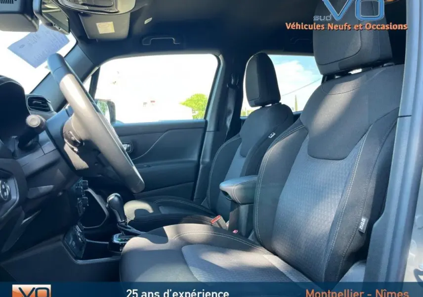 Vue intérieure côté conducteur du Jeep Renegade gris foncé, mettant en valeur les sièges et le volant réglable.