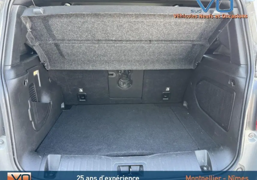 Coffre ouvert du Jeep Renegade gris foncé 80th Anniversary montrant l'espace de chargement intérieur vide.
