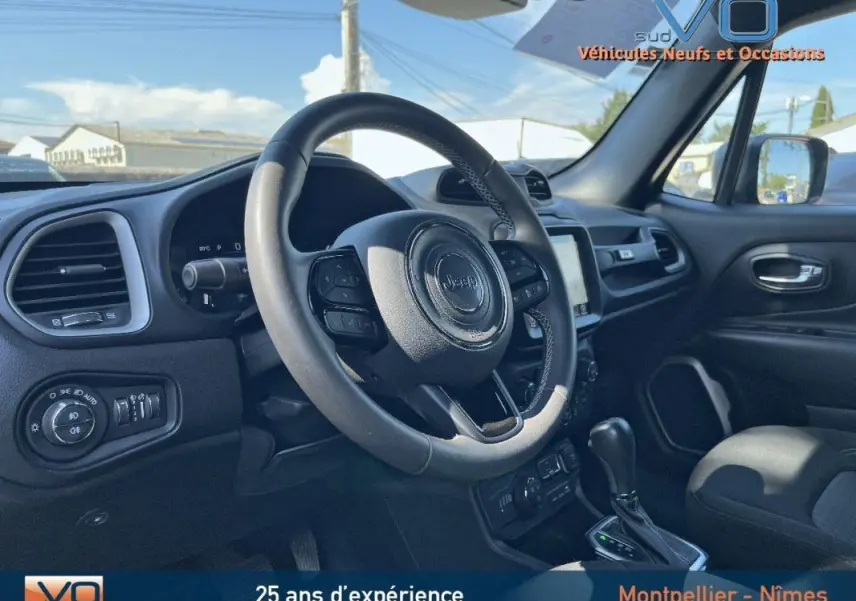 Intérieur du Jeep Renegade 2021 vu côté conducteur, volant cuir, écran tactile et tableau de bord moderne noirs.