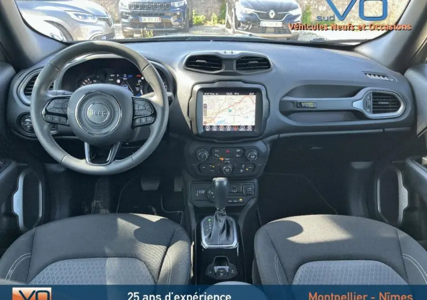 Vue intérieure avant du Jeep Renegade gris foncé 2021, avec écran tactile GPS et volant multifonction.