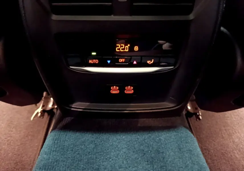 Panneau de commande de climatisation arrière avec affichage digital à 22°C dans une BMW Série 3 noire 318i M Sport.