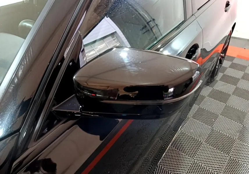 Rétroviseur côté gauche noir brillant d'une BMW Série 3 318i M Sport 2022, vue rapprochée sur la portière et la vitre.