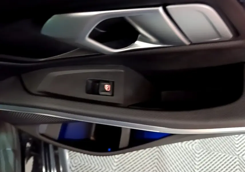 Détail de la poignée intérieure côté gauche d'une BMW Série 3 318i noire avec bouton de verrouillage des vitres.