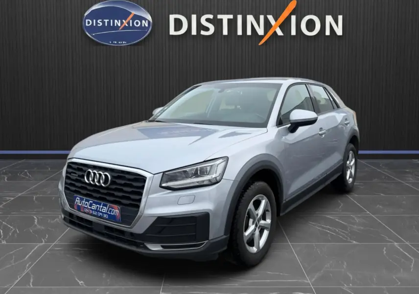 Audi Q2 gris aluminium en 3/4 avant droit, avec calandre noire et jantes alliage 5 branches visibles.