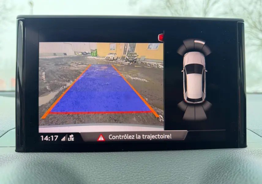 Écran de caméra de recul et vue 360° du tableau de bord de l'Audi Q2 gris aluminium en stationnement.