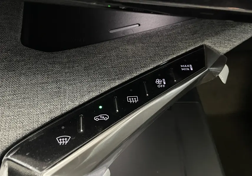 Détail du panneau de commandes de climatisation tactile noir dans l’habitacle du Peugeot 3008 Hybrid 2026.