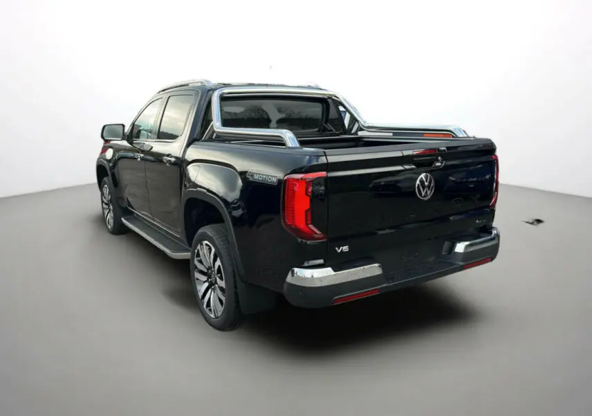 Volkswagen Amarok V6 noir vu 3/4 arrière droit avec arceaux inox et jantes alu 21 pouces.