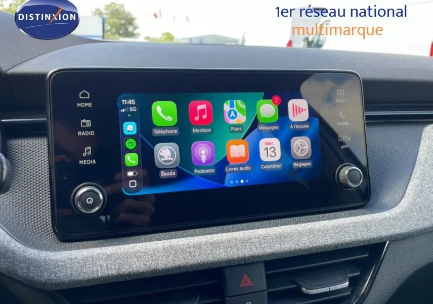 Écran tactile central affichant l'interface Apple CarPlay dans l'habitacle d'une Skoda Scala blanche Glacier.