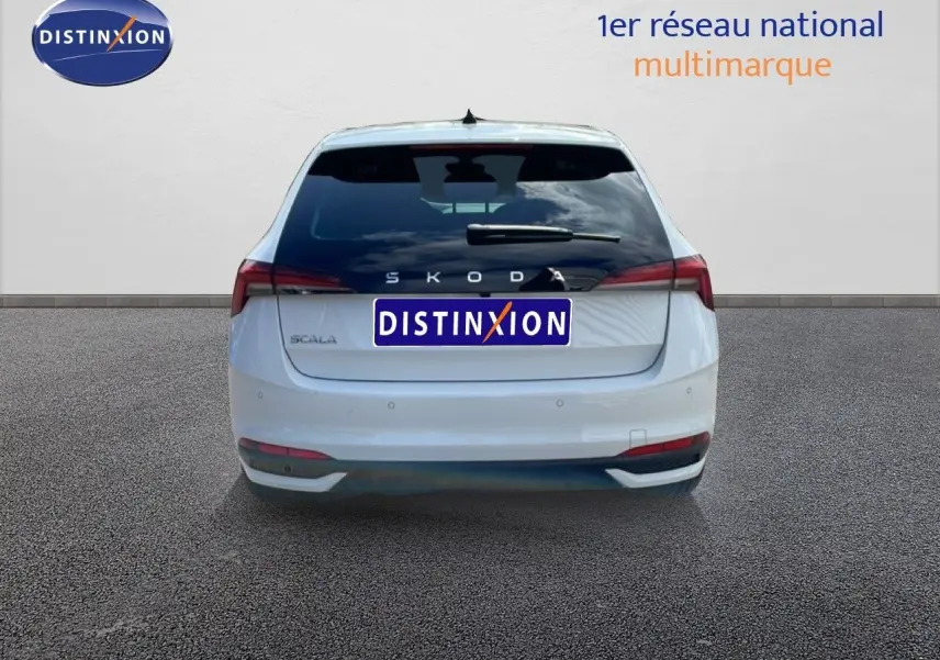 Vue arrière d'une Skoda Scala blanche glacier 2025, avec feux arrière allongés et logo distinctif au centre.