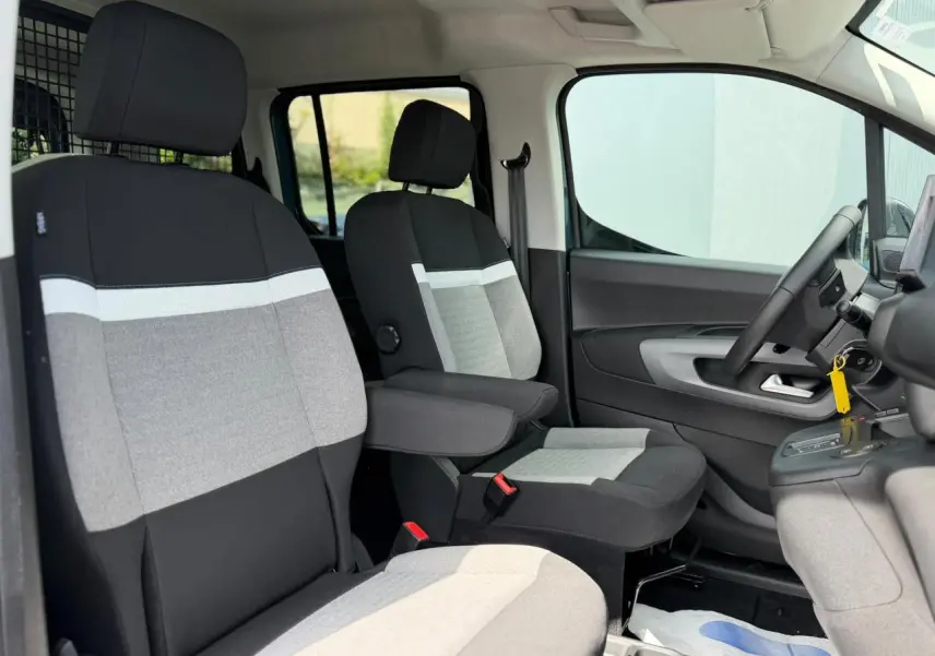 Vue intérieure côté droit du Citroën Berlingo Multispace 2026, sièges tissu gris et noir avec accoudoirs.