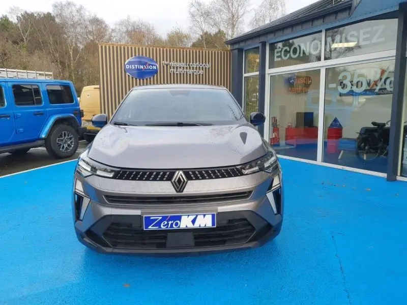 Vue avant du Renault Captur 2025 gris Cassiopée avec calandre moderne et logo Renault bien visible.