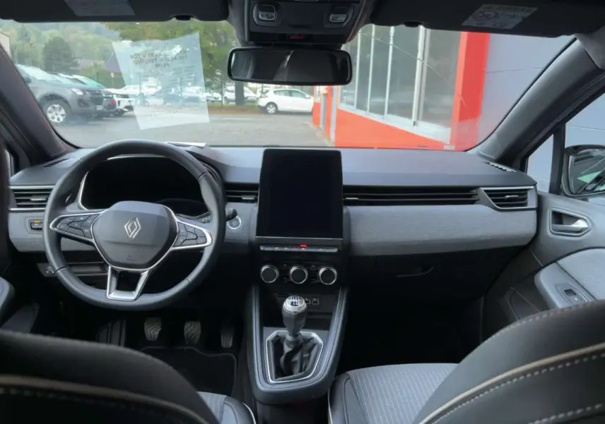 Intérieur de la Renault Clio V TCe 100 Eco-G Techno Plus 2025, vue frontale du tableau de bord et volant cuir multifonctions.