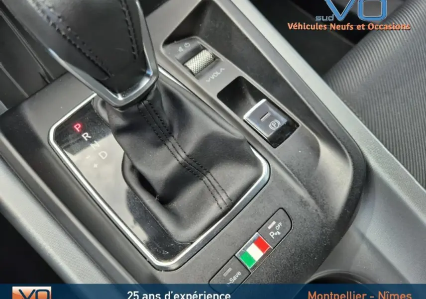 Gros plan sur la console centrale de l'Alfa Romeo Tonale 2023, avec levier de vitesse automatique et badge tricolore italien.