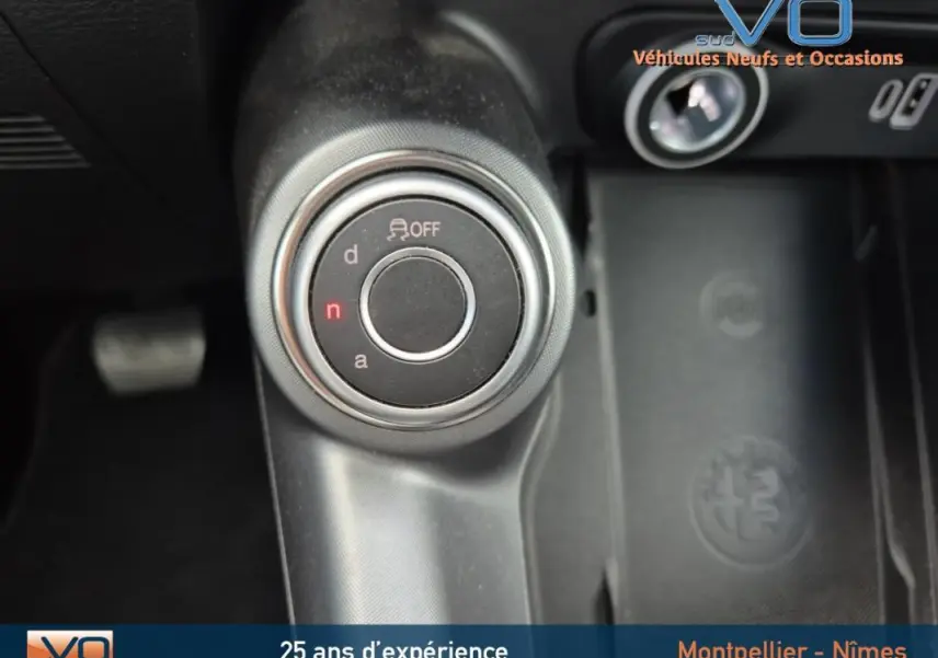 Gros plan sur la molette de sélection de mode de conduite dans l'Alfa Romeo Tonale gris 2023, intérieur noir.