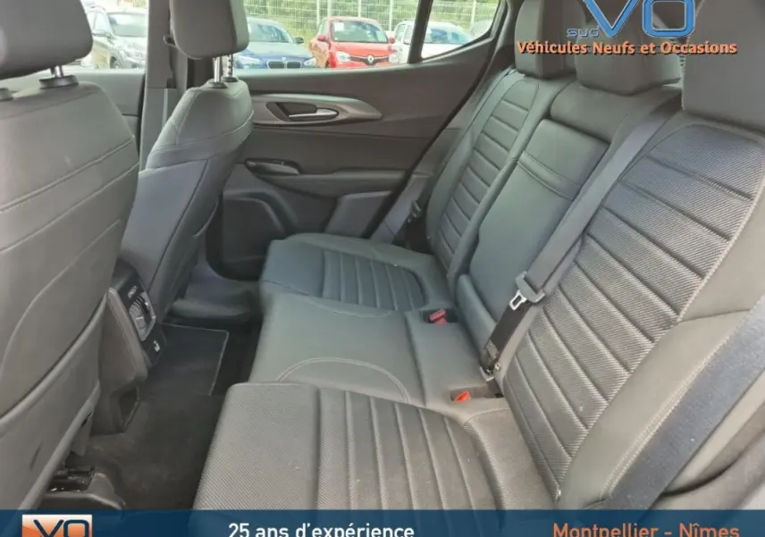 Vue intérieure arrière montrant les sièges arrière en cuir gris de l'Alfa Romeo Tonale 2023, avec accoudoir central et ceintures visibles.