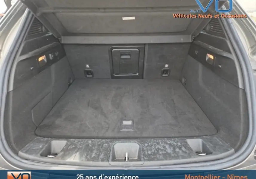 Coffre ouvert d'une Alfa Romeo Tonale gris 2023, montrant un espace de chargement propre et bien aménagé.